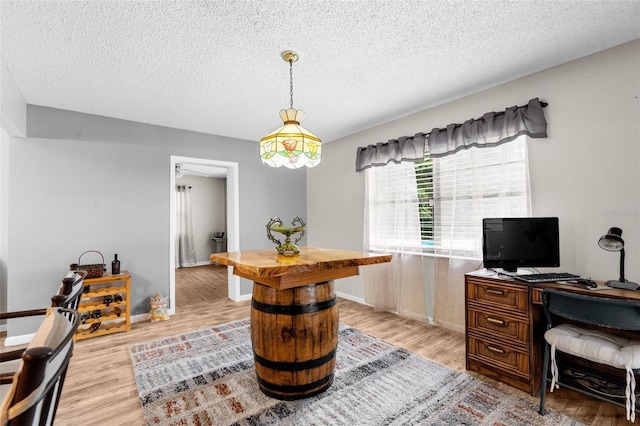 office with ceiling fan, light hardwood / wood-style flooring, and a textured ceiling