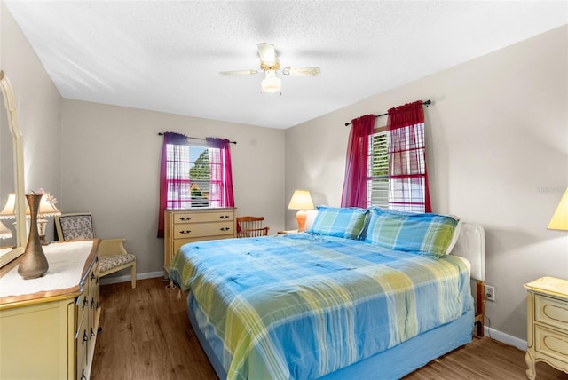 bedroom featuring ceiling fan, light wood-type flooring, and a textured ceiling