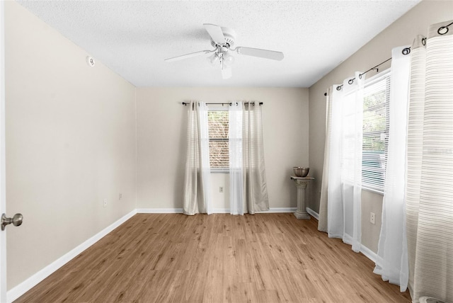 empty room featuring a textured ceiling, light hardwood / wood-style flooring, and ceiling fan