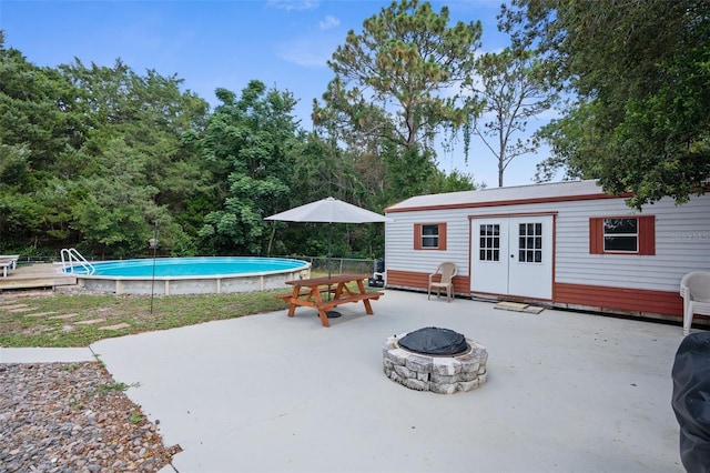 view of pool with a patio area, an outbuilding, and an outdoor fire pit