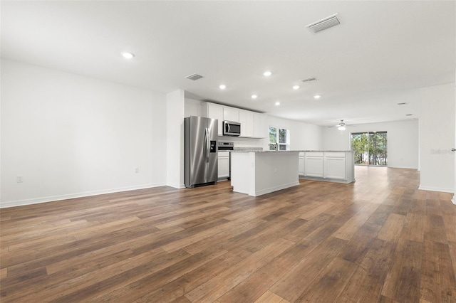 kitchen with stainless steel appliances, ceiling fan, a center island, dark hardwood / wood-style floors, and white cabinetry