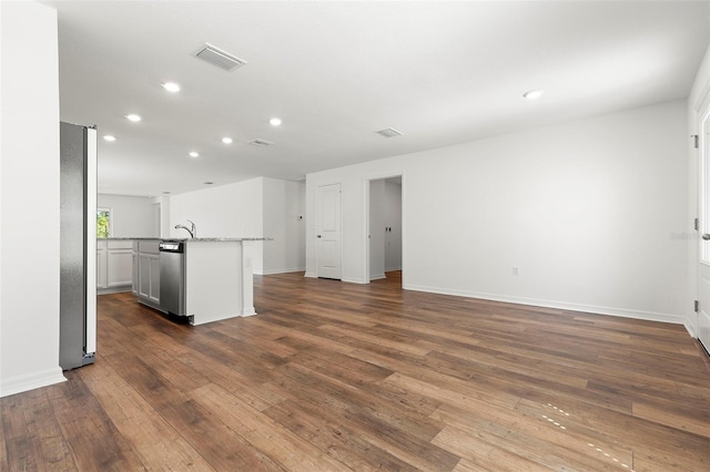 unfurnished living room featuring dark wood-type flooring and sink