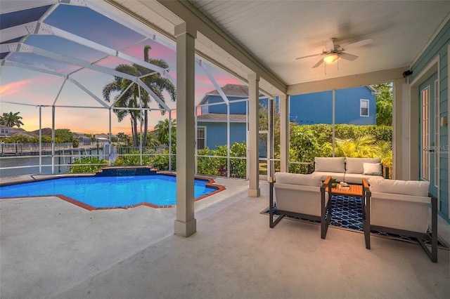 pool at dusk featuring an outdoor living space, a patio, ceiling fan, and glass enclosure