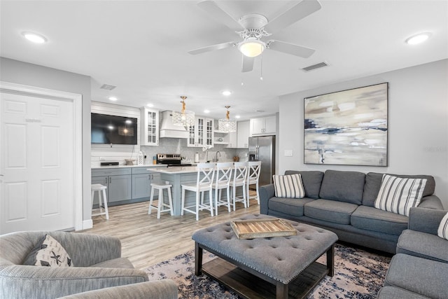 living room with light hardwood / wood-style floors and ceiling fan