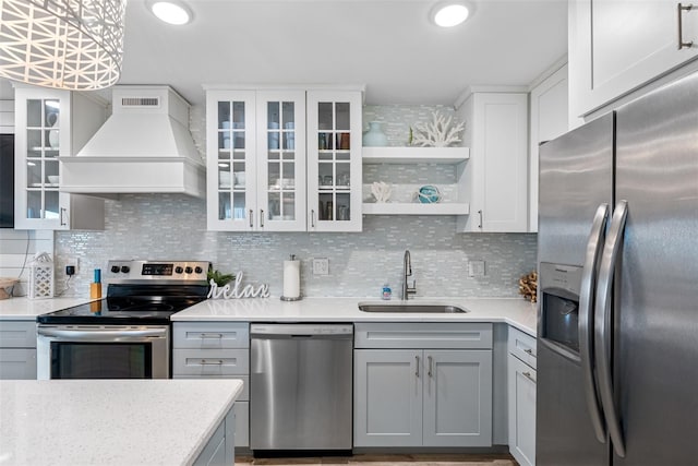 kitchen with sink, gray cabinets, premium range hood, white cabinetry, and stainless steel appliances