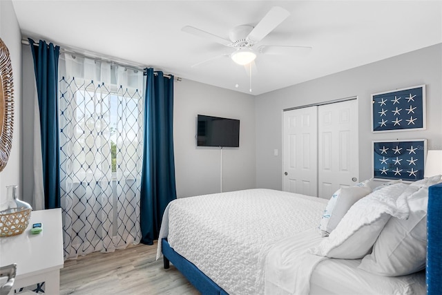 bedroom featuring ceiling fan, light hardwood / wood-style floors, and a closet