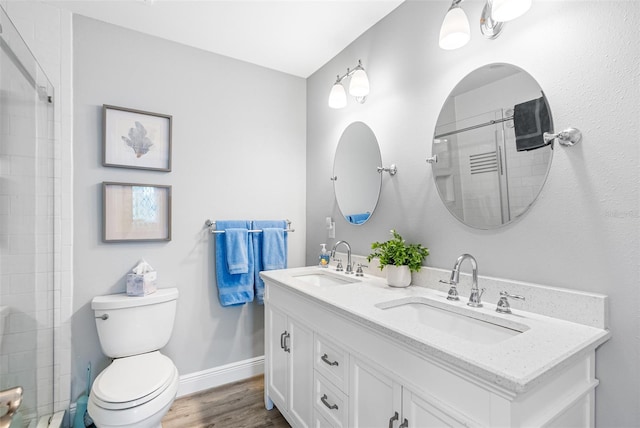 bathroom with vanity, hardwood / wood-style floors, an enclosed shower, and toilet