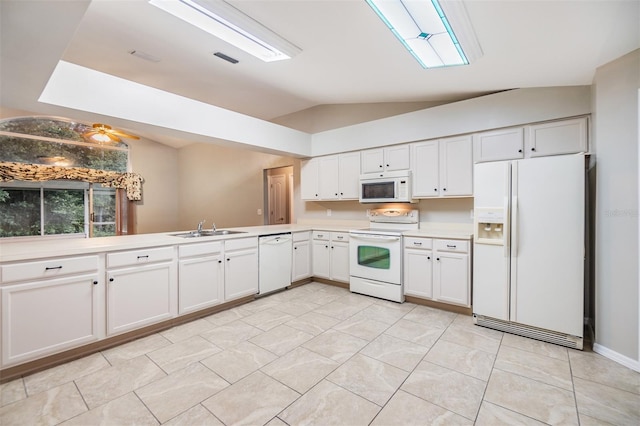 kitchen with sink, white appliances, white cabinets, vaulted ceiling, and kitchen peninsula