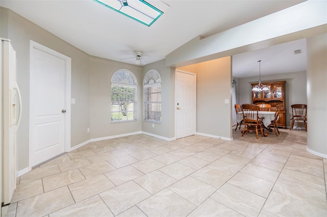 interior space with ceiling fan with notable chandelier and light tile patterned floors