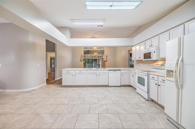 kitchen featuring sink, light tile patterned floors, kitchen peninsula, white appliances, and white cabinets