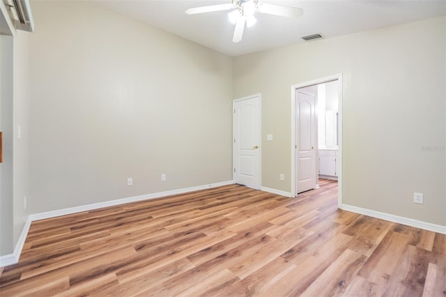 empty room featuring vaulted ceiling, ceiling fan, and light wood-type flooring