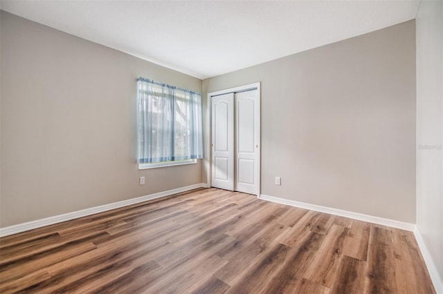 unfurnished bedroom featuring hardwood / wood-style flooring and a closet