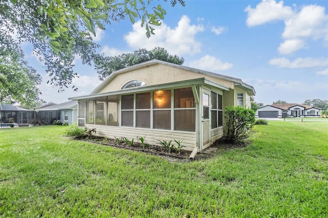 exterior space featuring a yard and a sunroom