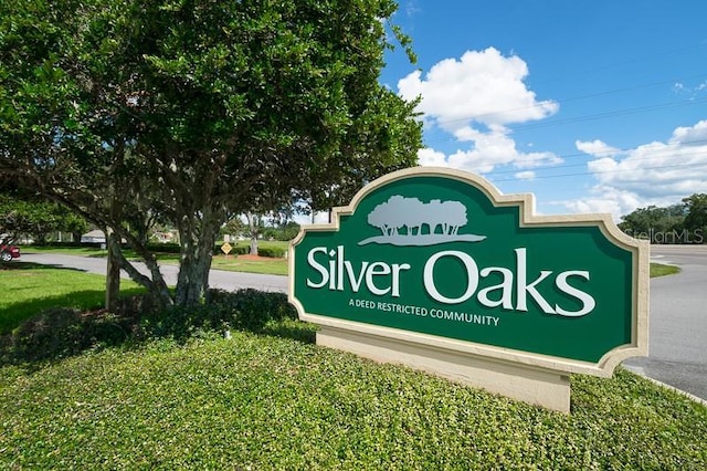 community / neighborhood sign featuring a yard