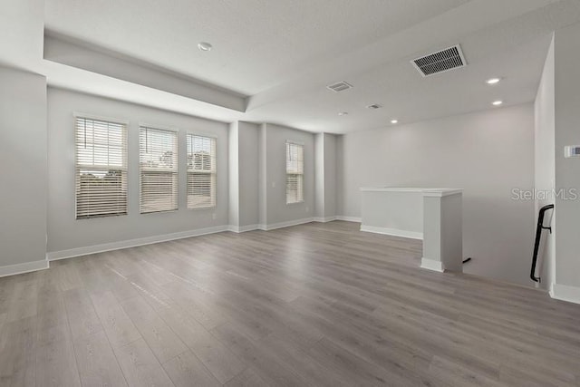 empty room featuring hardwood / wood-style floors and a tray ceiling