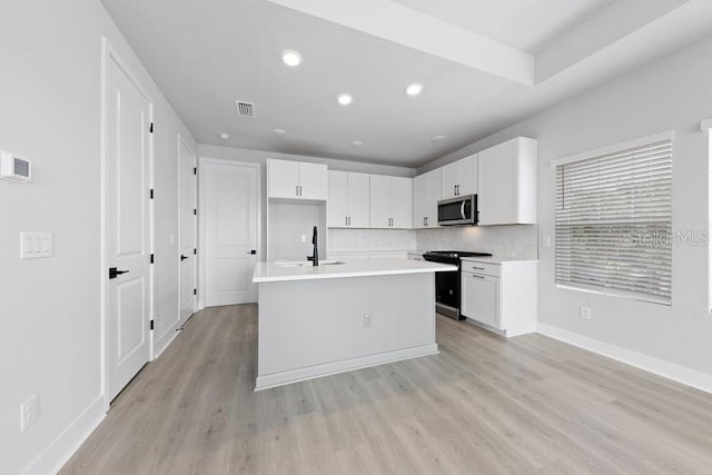 kitchen with sink, white cabinetry, electric range, an island with sink, and light wood-type flooring