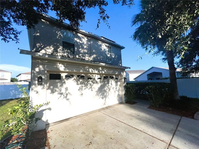 view of side of home with an outbuilding and fence