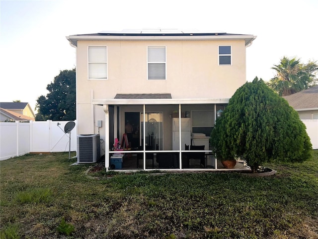 rear view of property with a lawn, central AC unit, a gate, a sunroom, and a fenced backyard