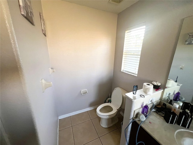 half bath with tile patterned flooring, toilet, and baseboards