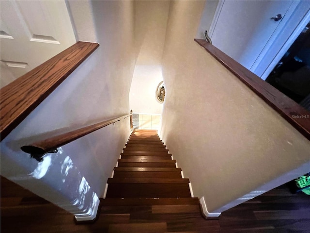 stairs featuring wood finished floors and baseboards