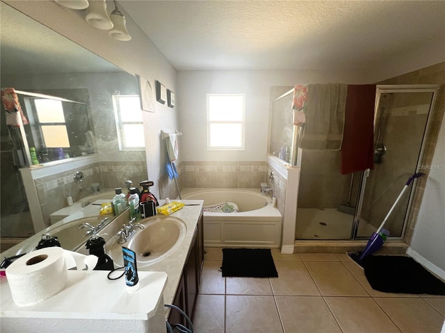 bathroom featuring a stall shower, a garden tub, tile patterned flooring, a textured ceiling, and vanity