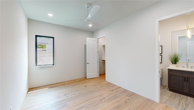 bedroom with ceiling fan, light wood-type flooring, sink, and connected bathroom