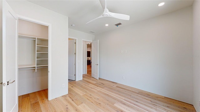 unfurnished bedroom featuring a closet, light hardwood / wood-style floors, and ceiling fan