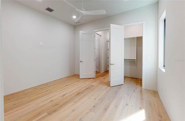 unfurnished bedroom with ceiling fan, a closet, and light hardwood / wood-style flooring