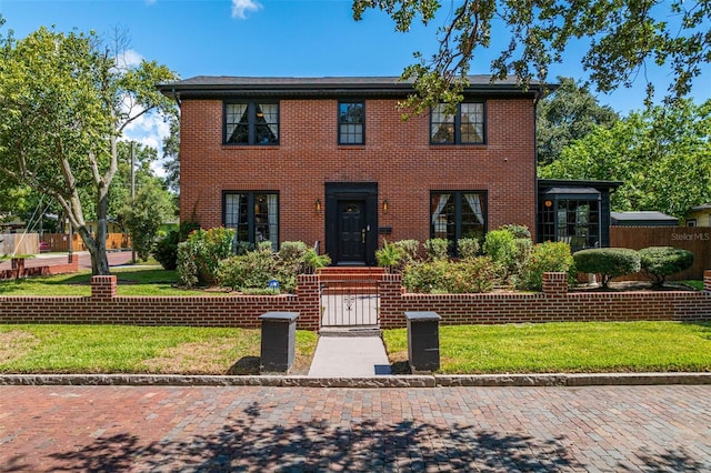 colonial-style house with a front lawn