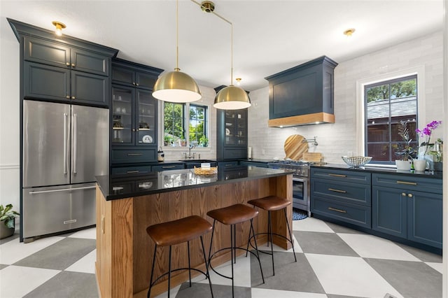 kitchen featuring custom exhaust hood, a center island, high quality appliances, a kitchen breakfast bar, and decorative light fixtures