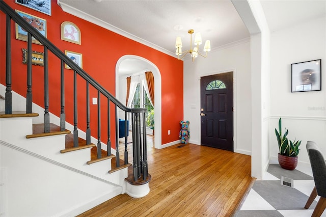 foyer featuring a chandelier, hardwood / wood-style floors, and ornamental molding