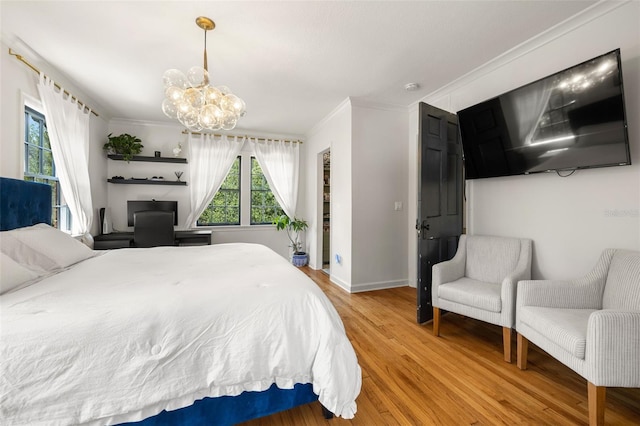 bedroom featuring wood-type flooring, ornamental molding, and a notable chandelier