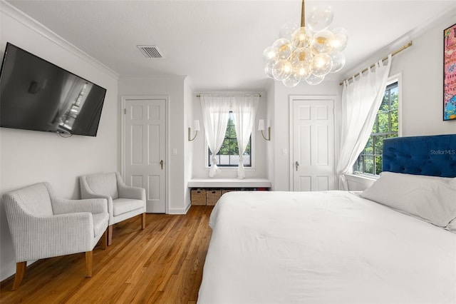 bedroom with hardwood / wood-style floors and a notable chandelier