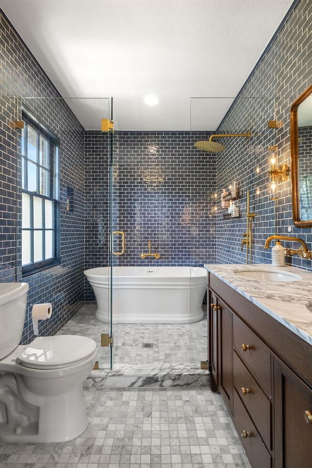 bathroom featuring vanity, a relaxing tiled tub, tile walls, and toilet