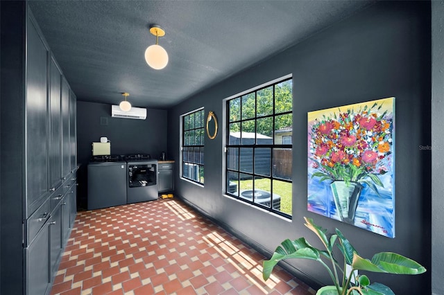 interior space featuring pendant lighting, separate washer and dryer, and a textured ceiling