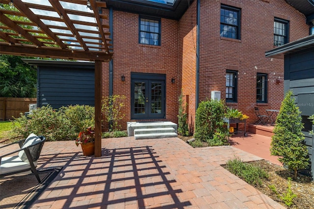 entrance to property featuring a pergola, a patio area, and french doors