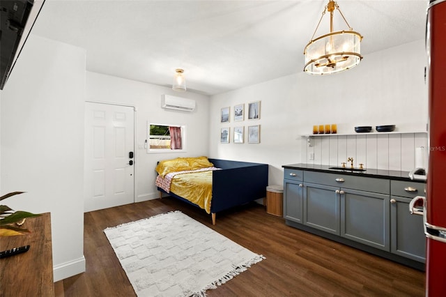 bedroom with dark hardwood / wood-style flooring, an inviting chandelier, and a wall unit AC