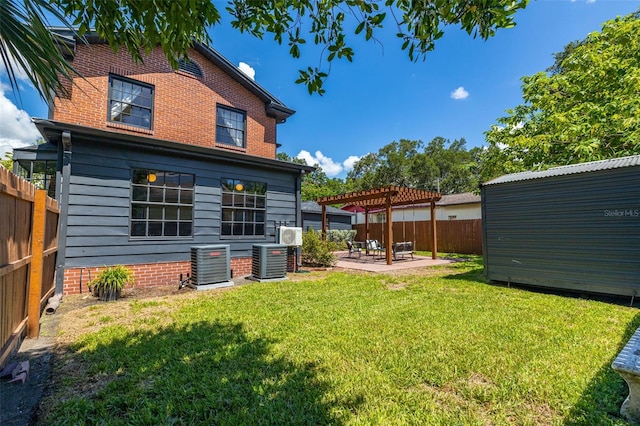 back of property featuring a pergola, a patio area, a lawn, and central AC