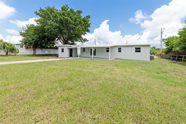 ranch-style home with a front yard and fence