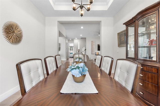 dining room featuring a tray ceiling, crown molding, and a notable chandelier