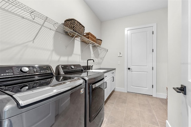 washroom featuring light tile patterned flooring, cabinets, independent washer and dryer, and sink