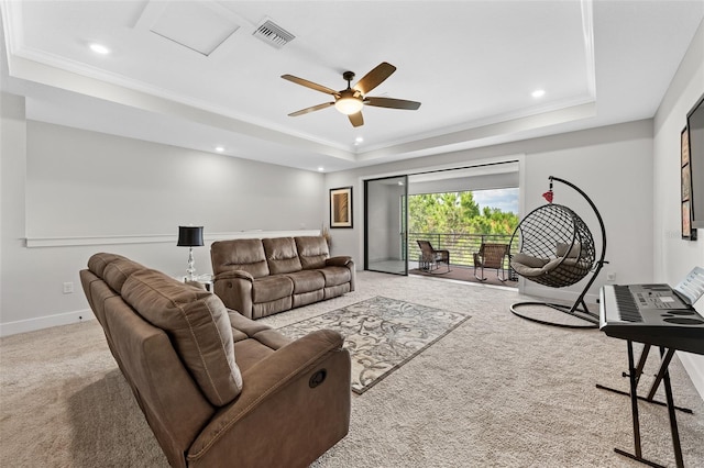 carpeted living room featuring a tray ceiling, ceiling fan, and crown molding