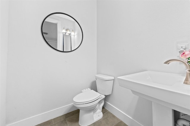 bathroom featuring toilet, tile patterned floors, and sink