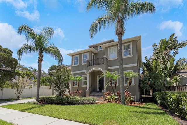 mediterranean / spanish house featuring a front yard and a balcony