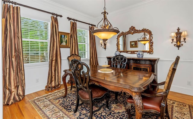 dining room with light hardwood / wood-style flooring and ornamental molding