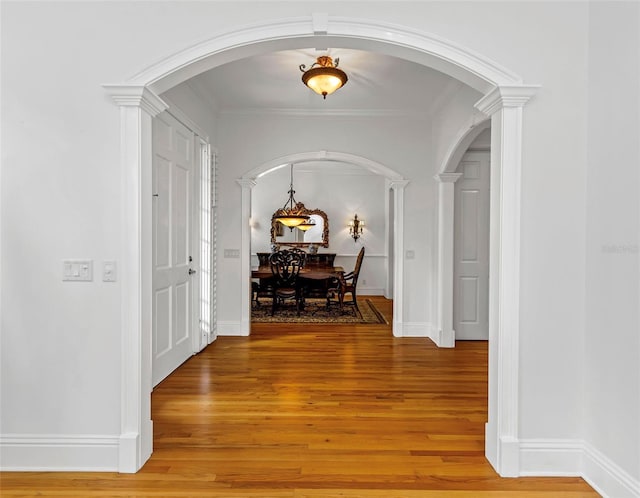 corridor with hardwood / wood-style floors and crown molding