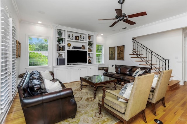 living room with light hardwood / wood-style flooring, ceiling fan, and crown molding