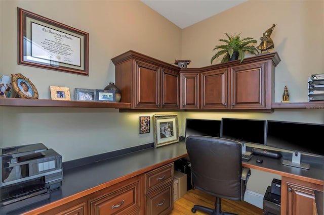 office with built in desk and light wood-type flooring