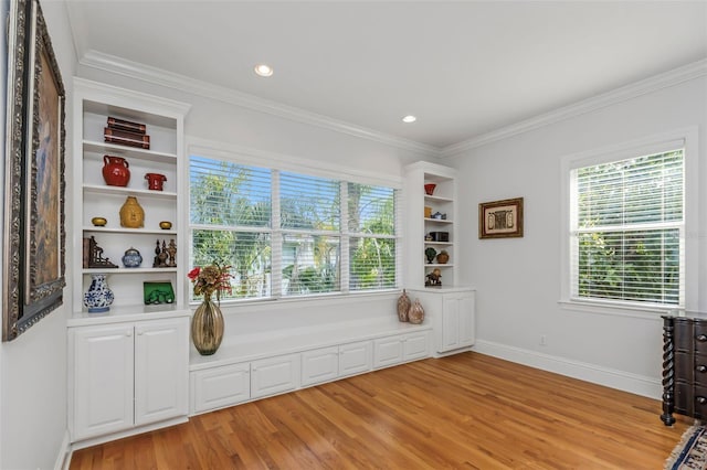 sitting room featuring light wood-type flooring and ornamental molding