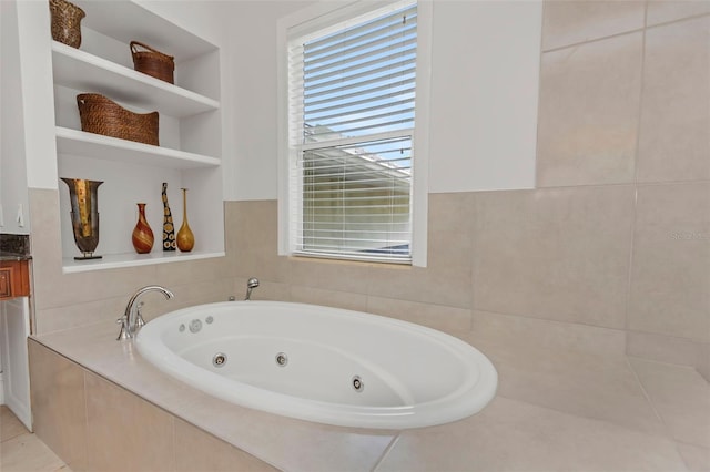 bathroom featuring vanity and tiled tub